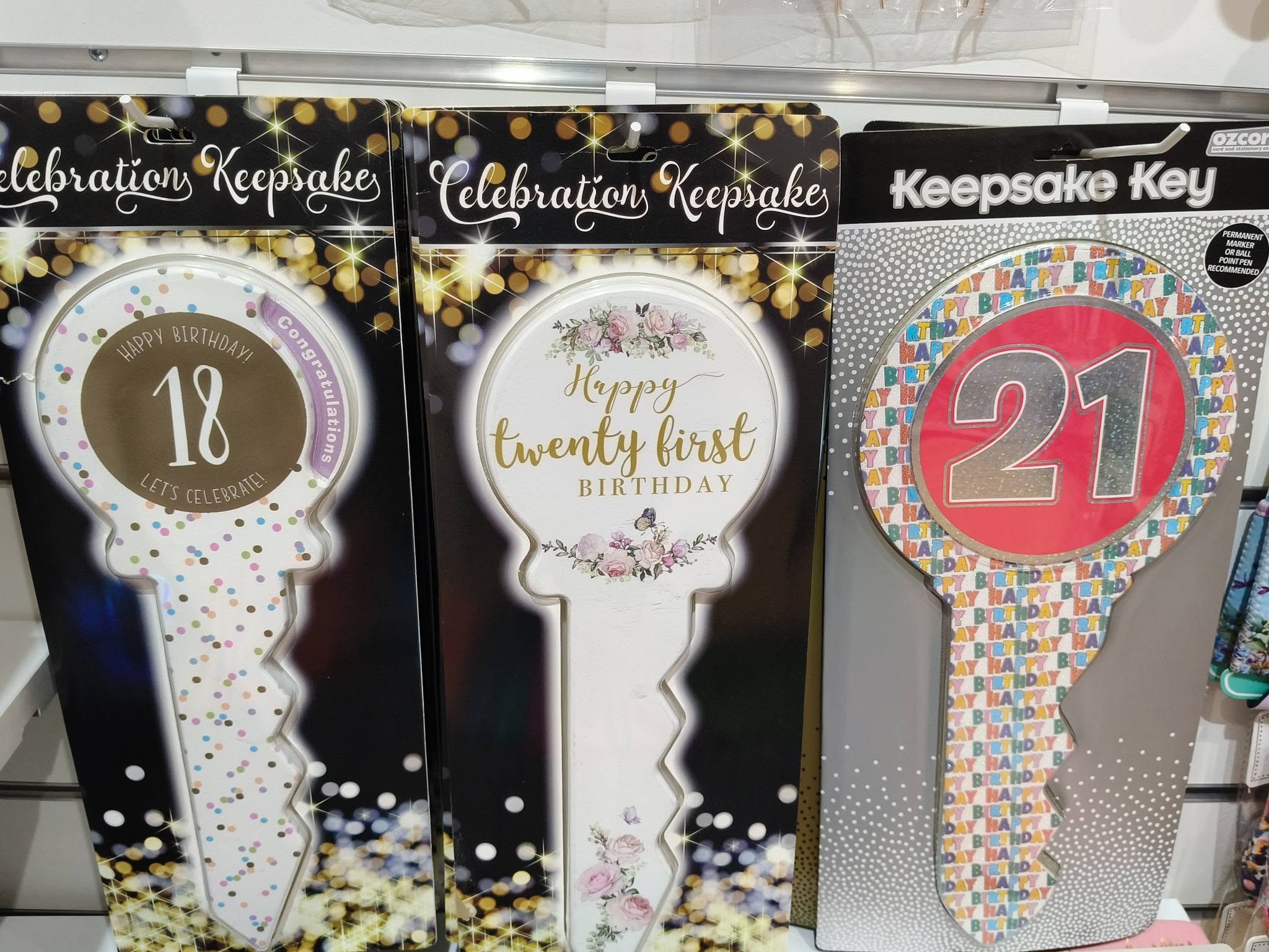 Celebration keepsake keys for 18th and 21st birthdays on a display wall